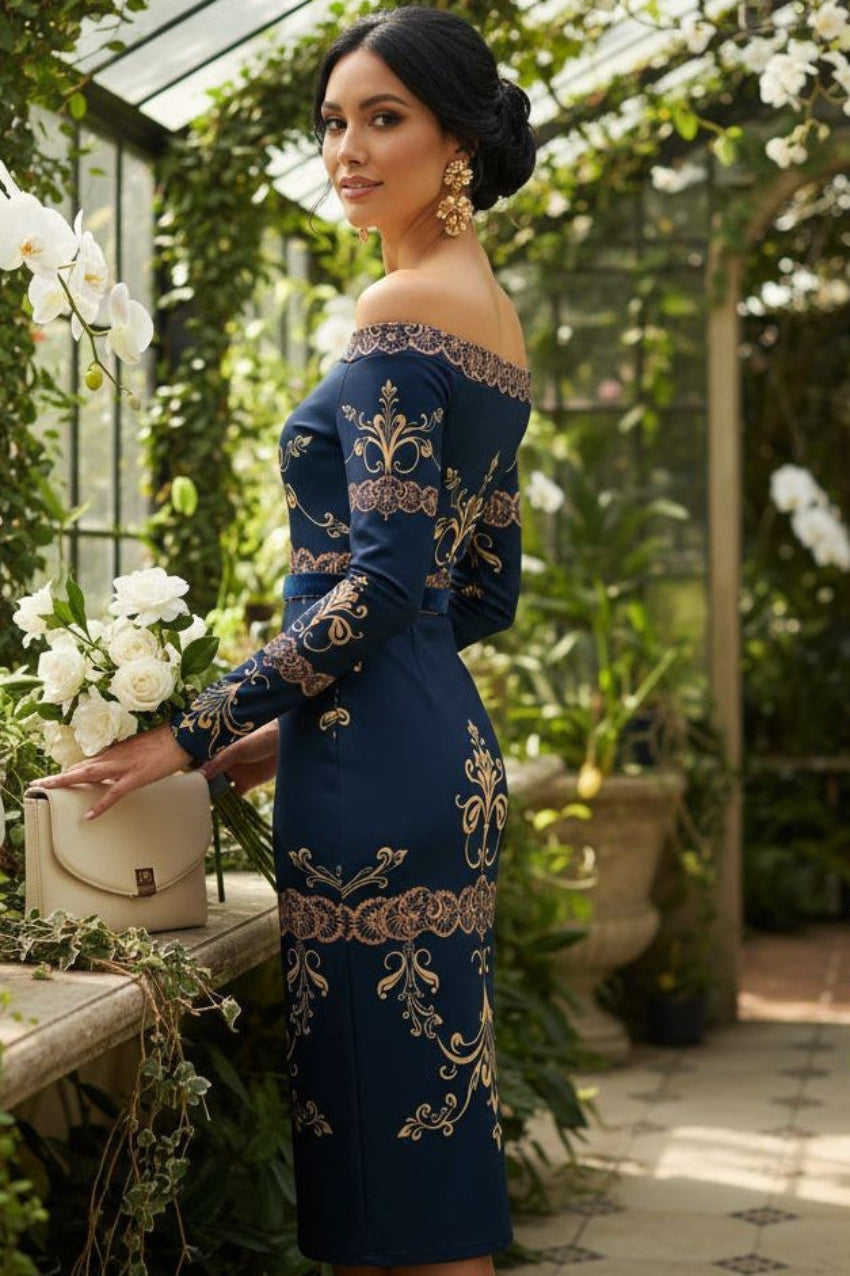 Woman wearing a navy blue off the shoulder wrap dress with gold embroidery in a greenhouse setting