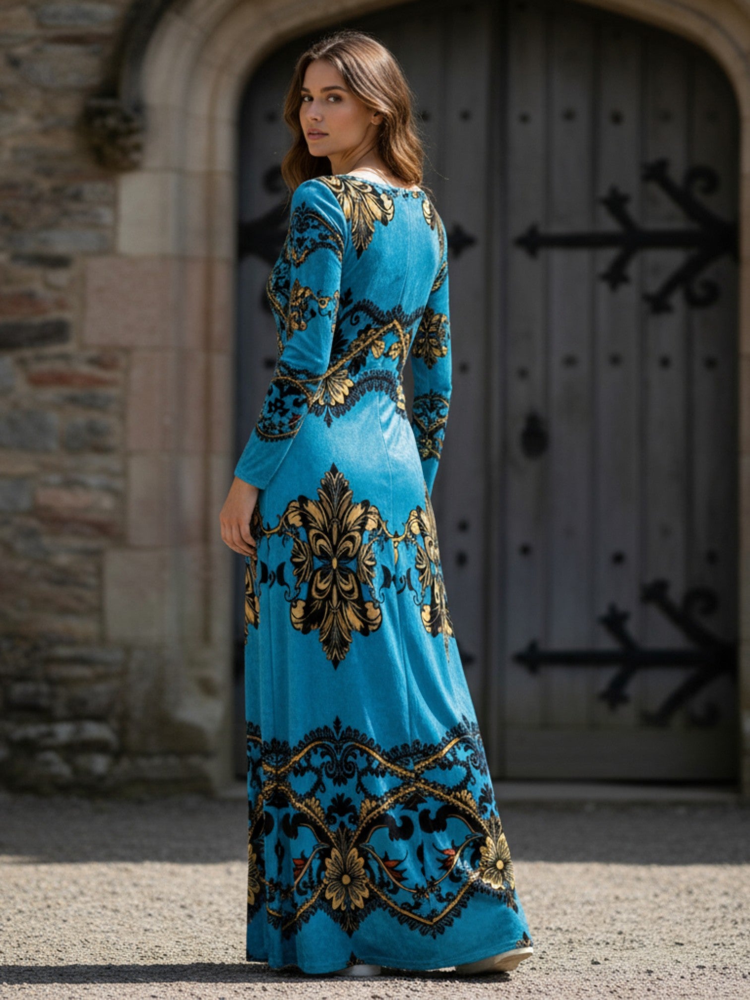 Woman wearing baroque print velvet maxi dress in blue and gold by Angelic Blessings Shop standing outdoors