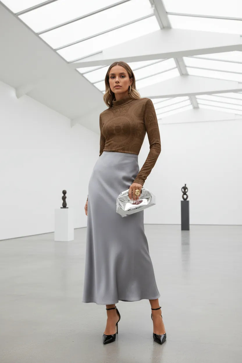 Woman wearing an elegant brown turtleneck top for women paired with a silver satin skirt and black heels