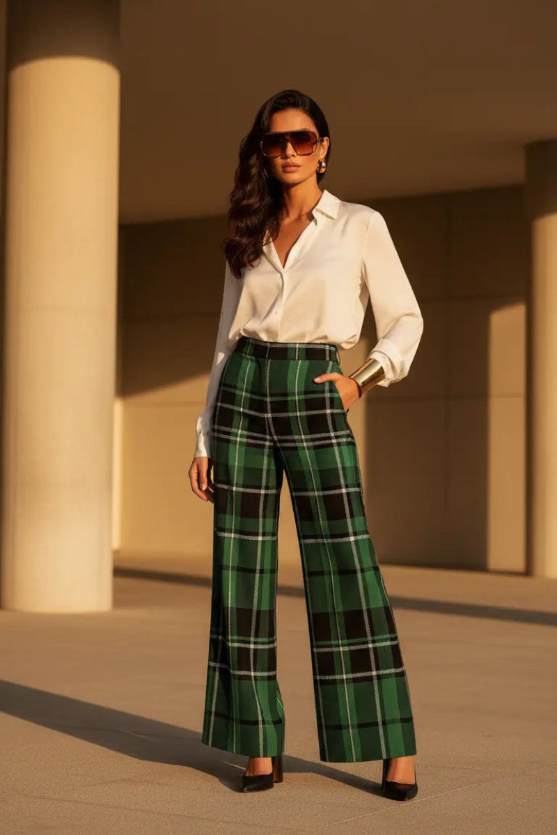 Woman wearing green tartan wide leg trousers paired with white blouse and sunglasses
