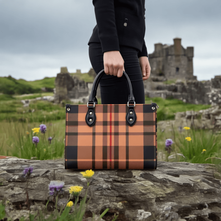 Heritage inspired designer handbags with plaid pattern and black handles held outdoors near ancient ruins