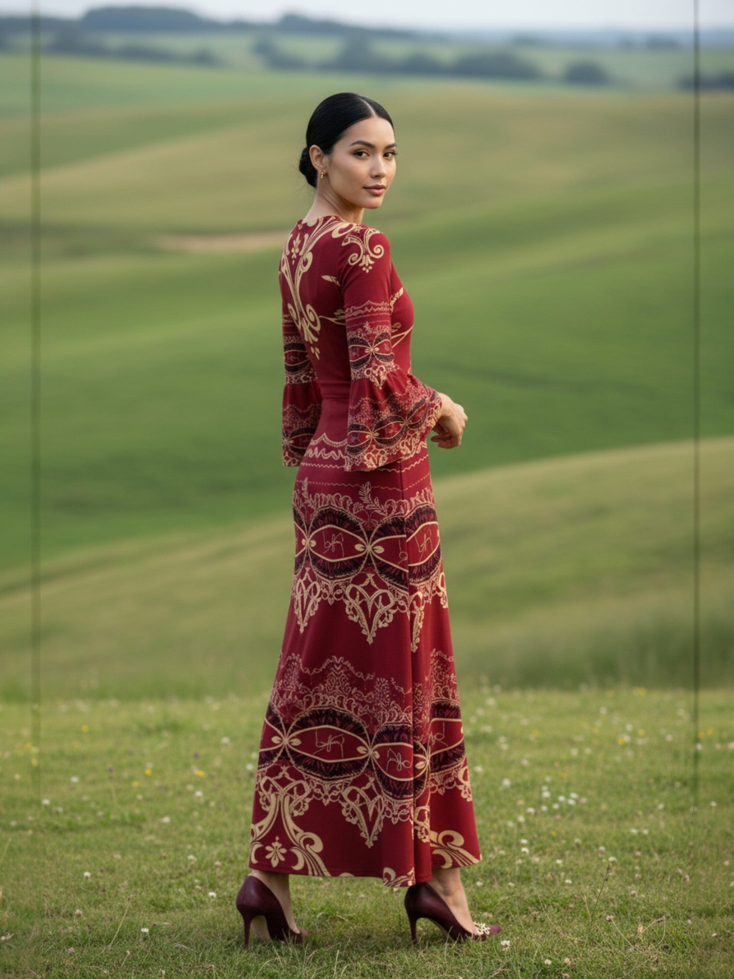 Woman wearing a red patterned long sleeve v-neck evening gown maxi dress standing on grass