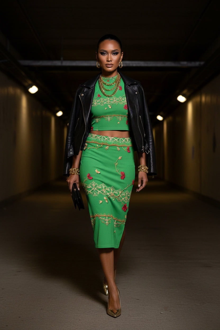 Model wearing green baroque two piece set with crop top and midi skirt styled with black leather jacket