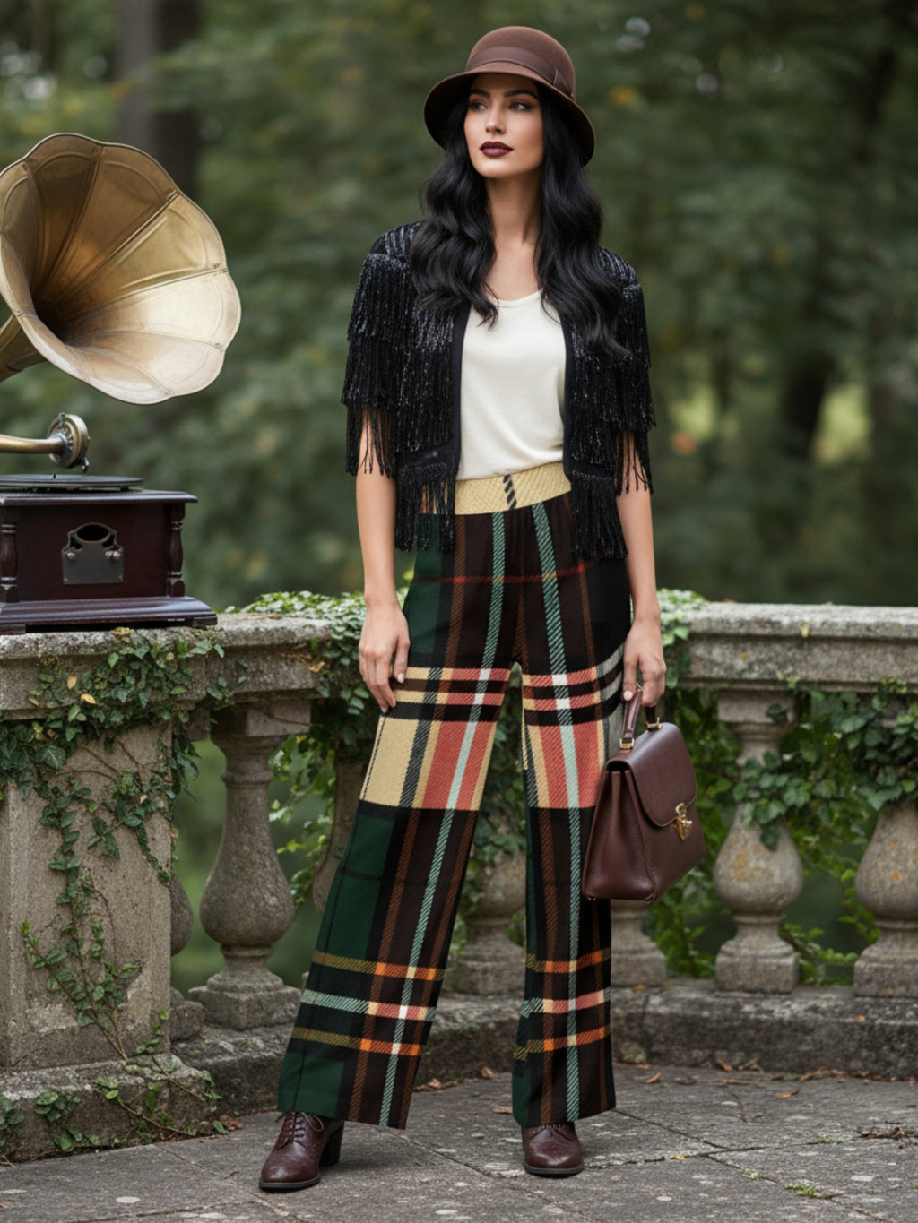 Woman wearing women's green tartan wide-leg trousers paired with black fringed jacket and brown hat outdoors